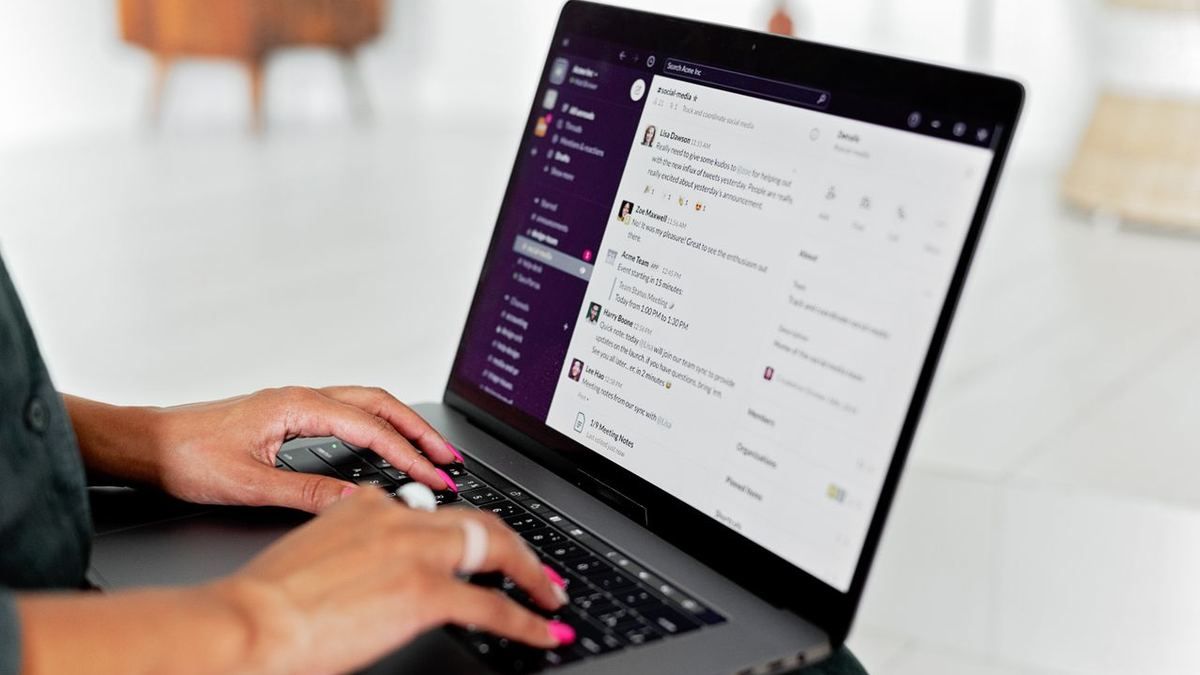 Person typing on a laptop showing a chat and messaging interface