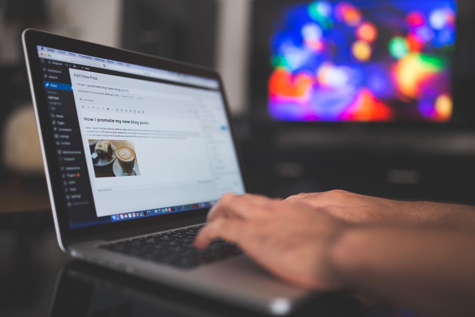 Person writing a blog post on a laptop at a desk