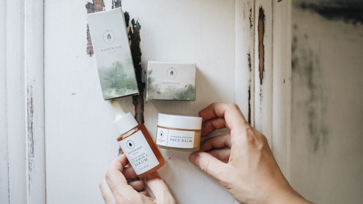 Hands holding handmade skincare product packaging