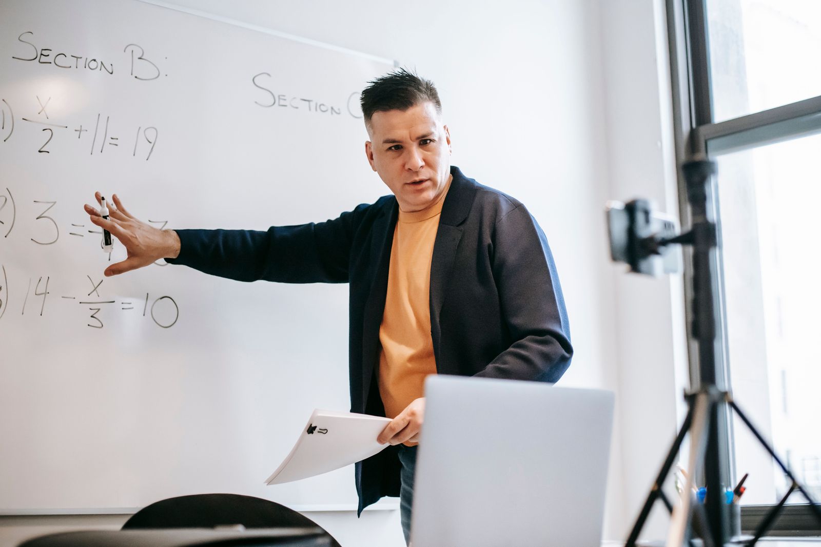 Online instructor teaching a course via video call on a laptop